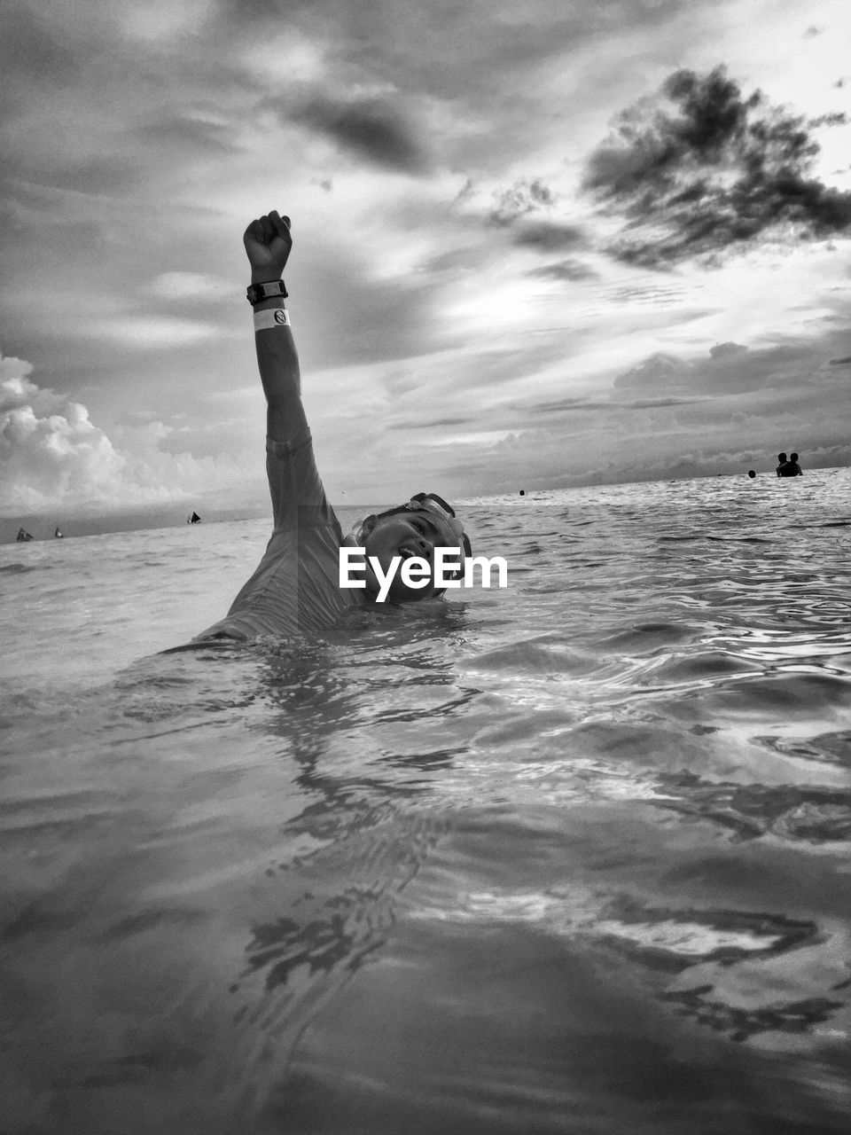 WOMAN SWIMMING IN SEA AGAINST SKY