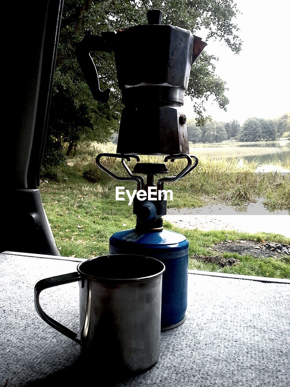 Coffee maker on stove by field
