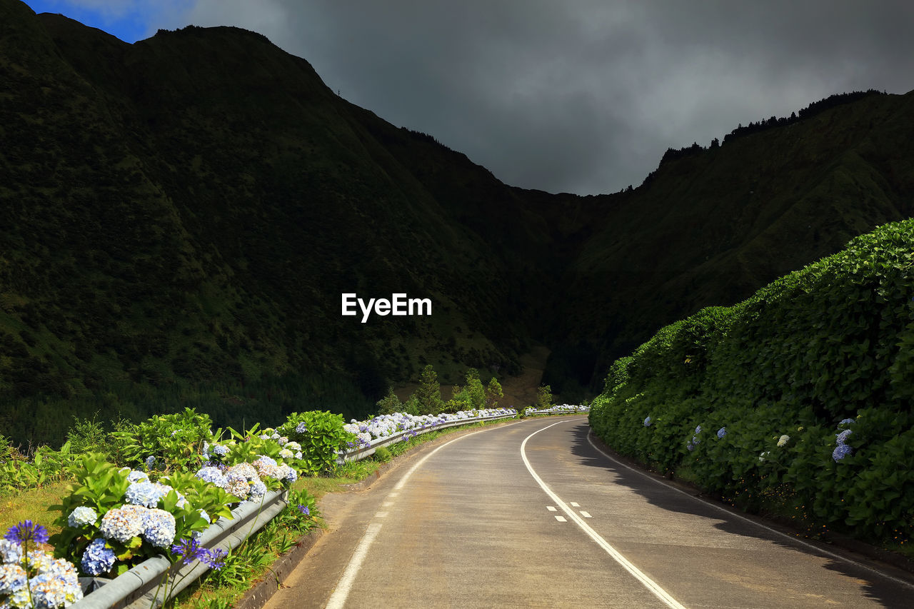 Sunlight falling on empty road against mountains at azores