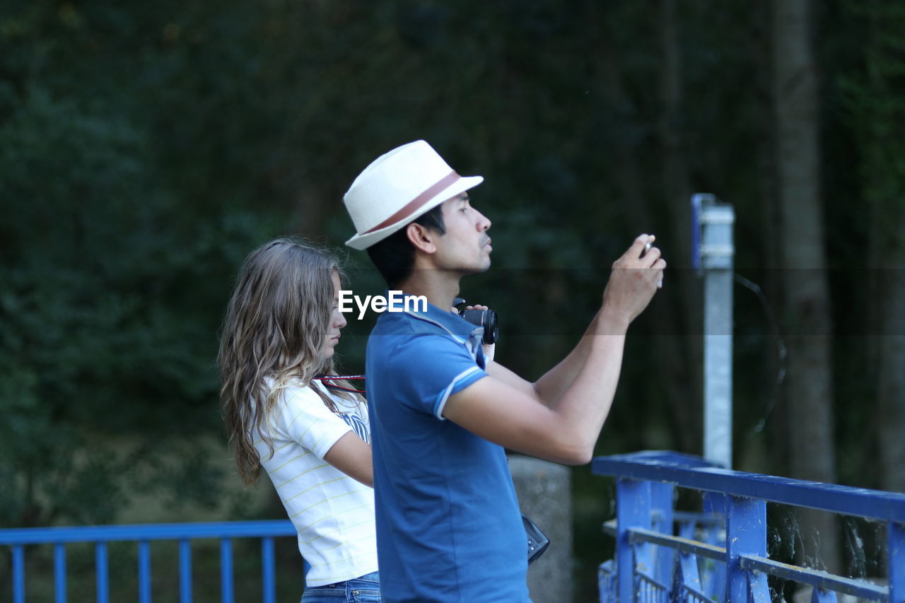 Side view of people photographing while standing at observation point