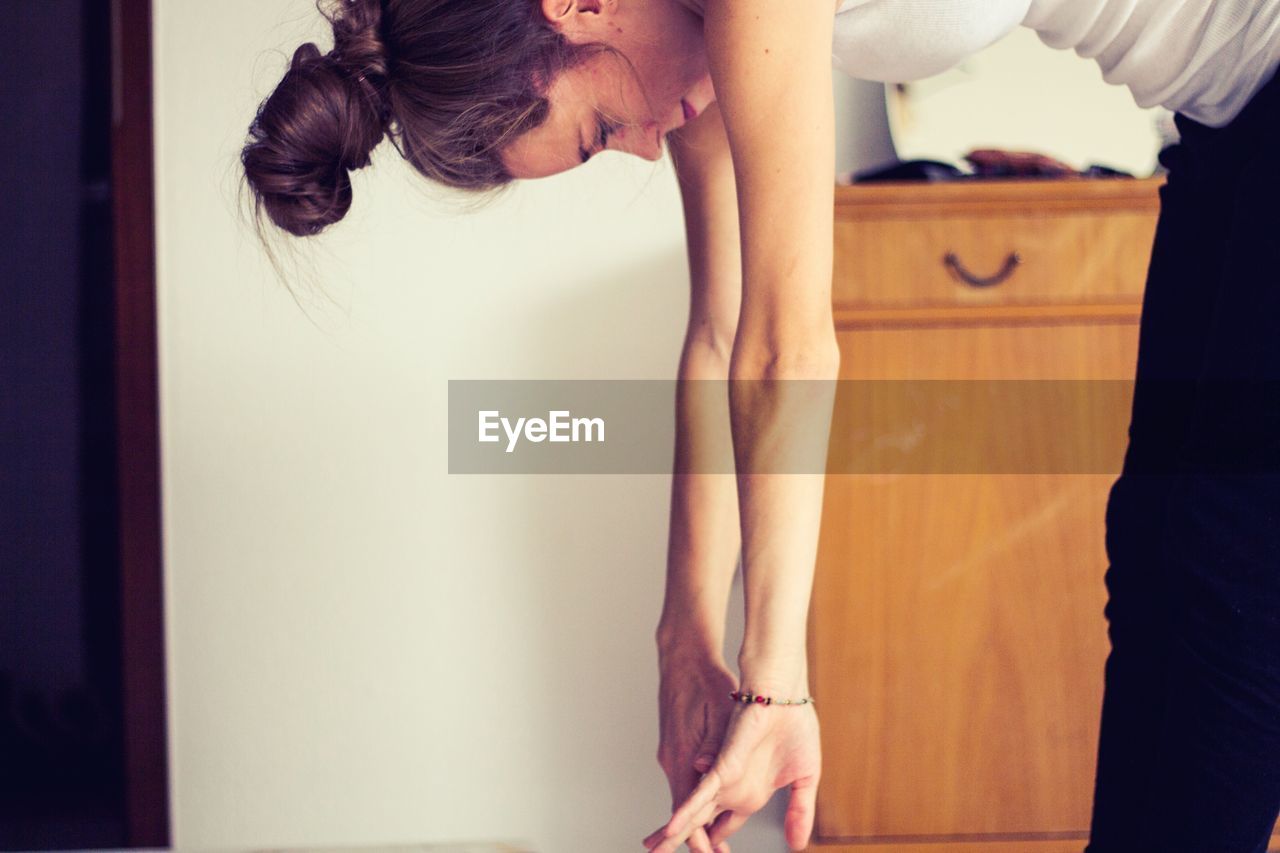 Side view of woman exercising at home