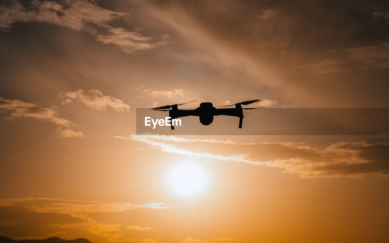 sky, sunset, silhouette, flying, cloud, nature, sun, mid-air, dawn, sunlight, air vehicle, airplane, evening, back lit, orange color, beauty in nature, transportation, aircraft, outdoors, horizon, dramatic sky, motion, mode of transportation, wing, vehicle, bird, travel, no people, sunbeam, low angle view