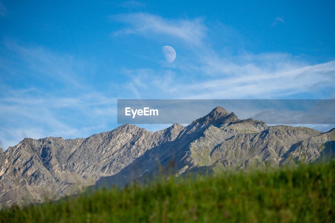 Scenic view of the moon and the mountains against sky