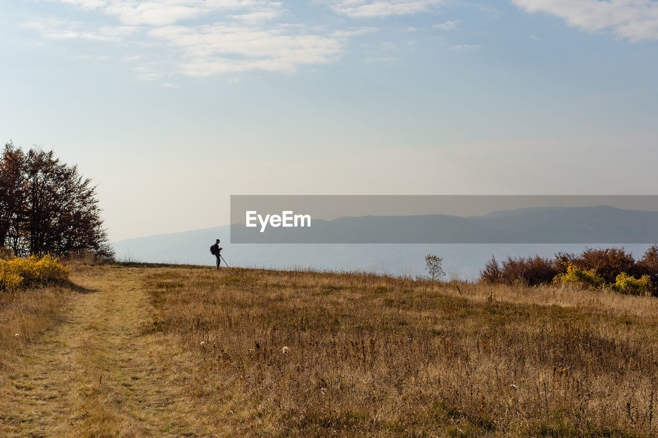 Silhouette of a man standing in mountains. blue sky background