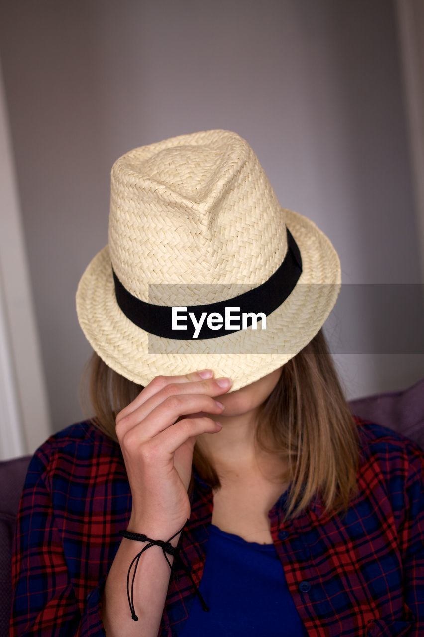 Woman with face covered by straw hat