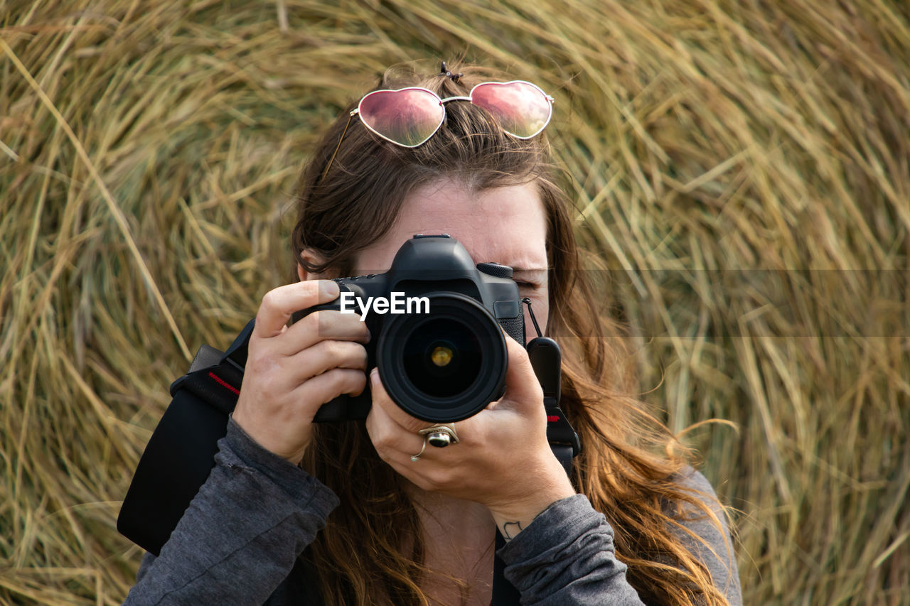 Portrait of woman photographing outdoors