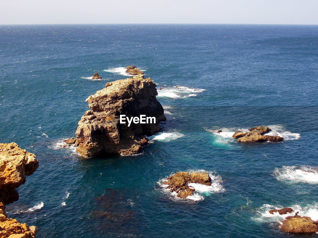 Rock formation in sea against sky