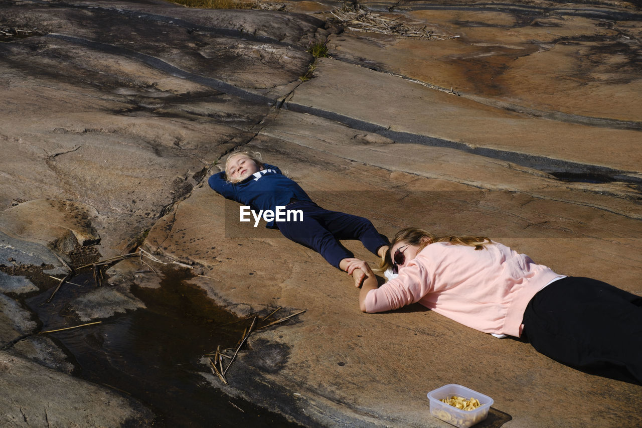 High angle view of people lying on rock