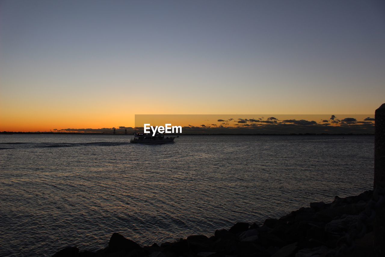 VIEW OF SEA AGAINST CLEAR SKY DURING SUNSET