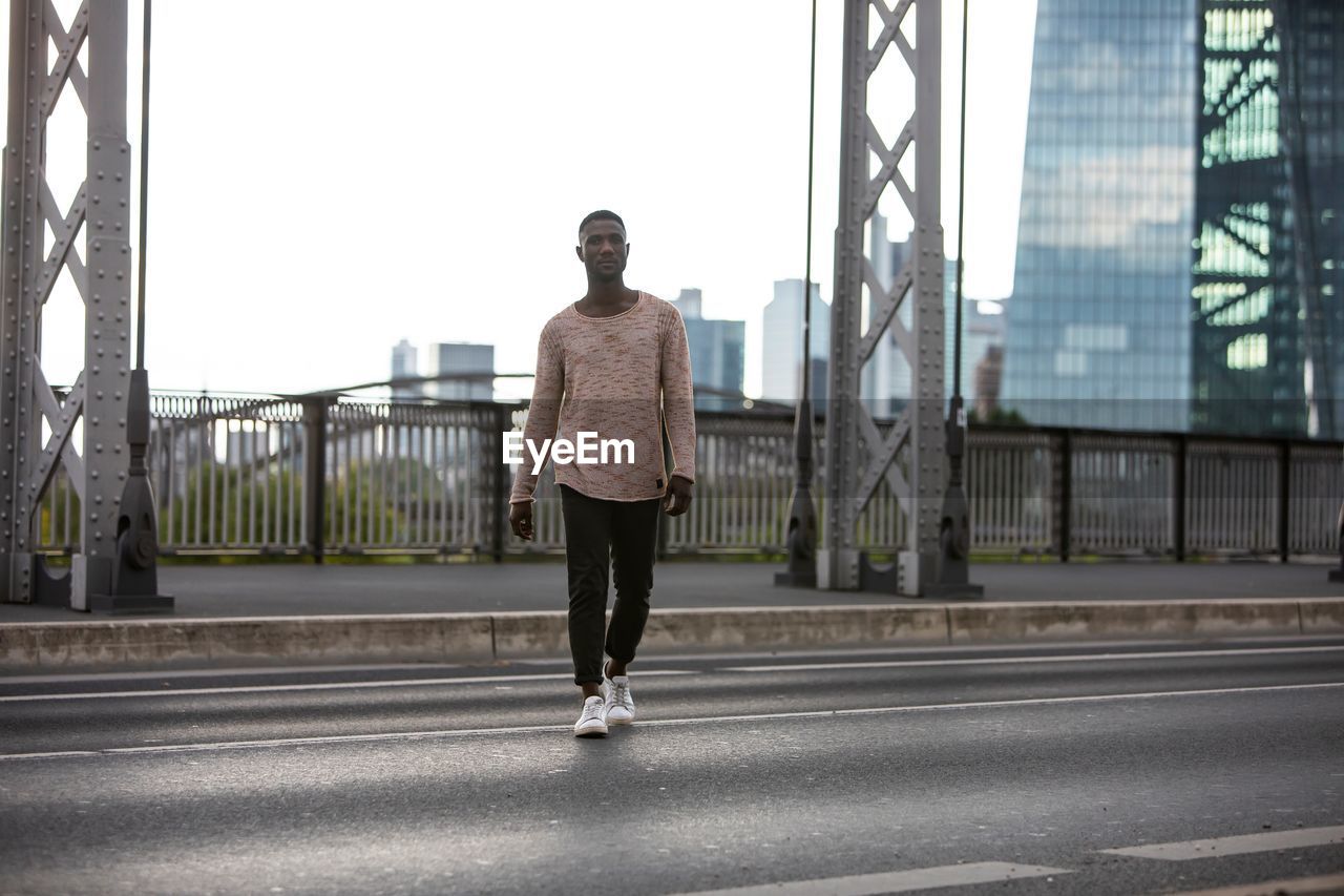 Portrait of young man walking on road