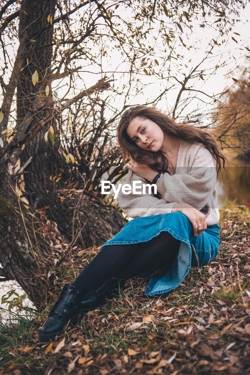 Young woman smiling while sitting on land