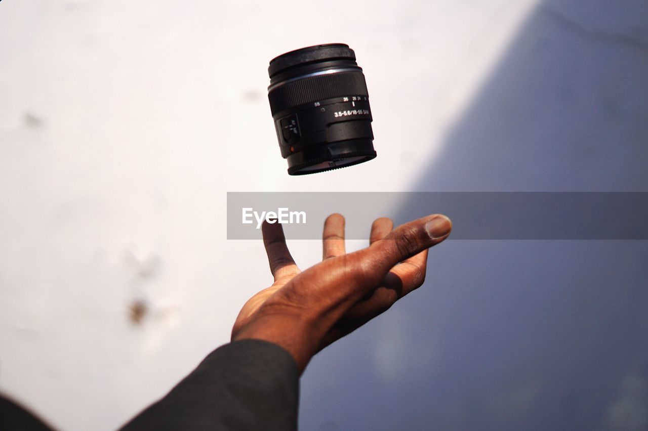 Close-up of hand throwing camera lens