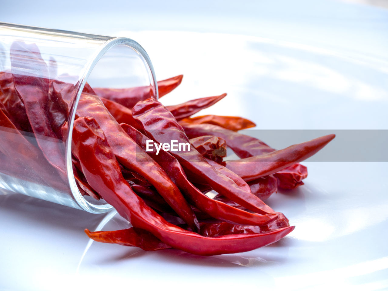 CLOSE-UP OF RED CHILI PEPPERS IN GLASS ON TABLE