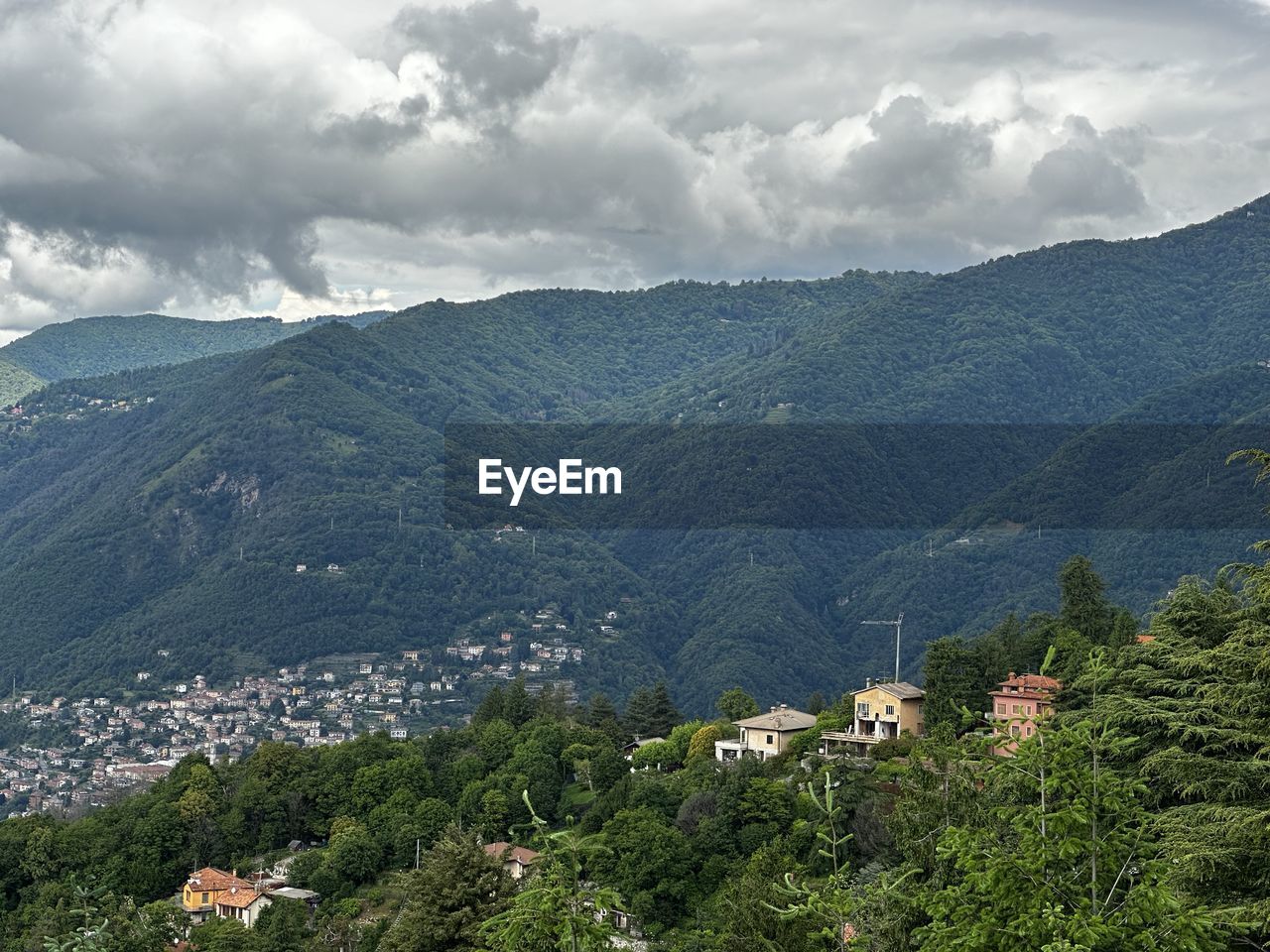 mountain, environment, landscape, mountain range, nature, scenics - nature, land, cloud, tree, plant, sky, architecture, beauty in nature, building, valley, built structure, building exterior, forest, travel destinations, travel, no people, house, village, rural scene, city, social issues, tourism, outdoors, highland, pinaceae, residential district, plateau, tranquility, ridge, coniferous tree, fog, high angle view, wilderness, pine tree, field, mountain pass, environmental conservation, tranquil scene, day, agriculture, mountain peak, religion, green, town, rural area, idyllic, overcast, hill station, growth, activity, summer