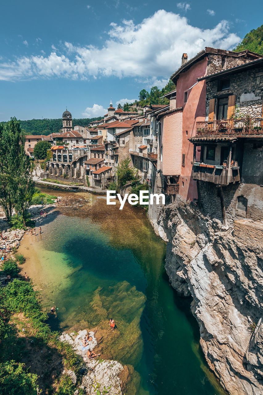 High angle view of buildings and river against cloudy sky