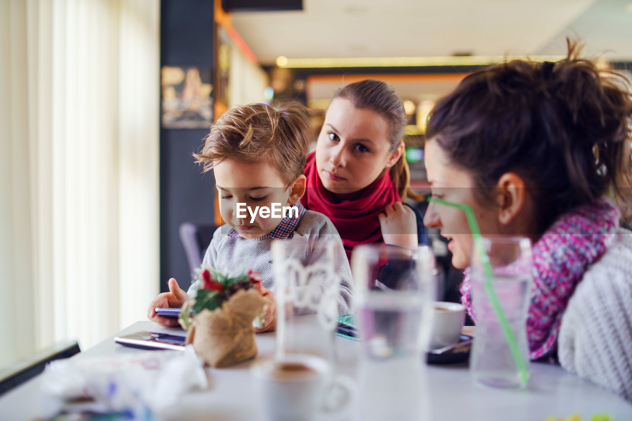 Women with boy sitting at table