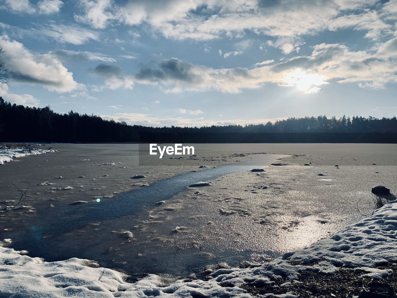 SCENIC VIEW OF FROZEN LAKE AGAINST SKY DURING WINTER