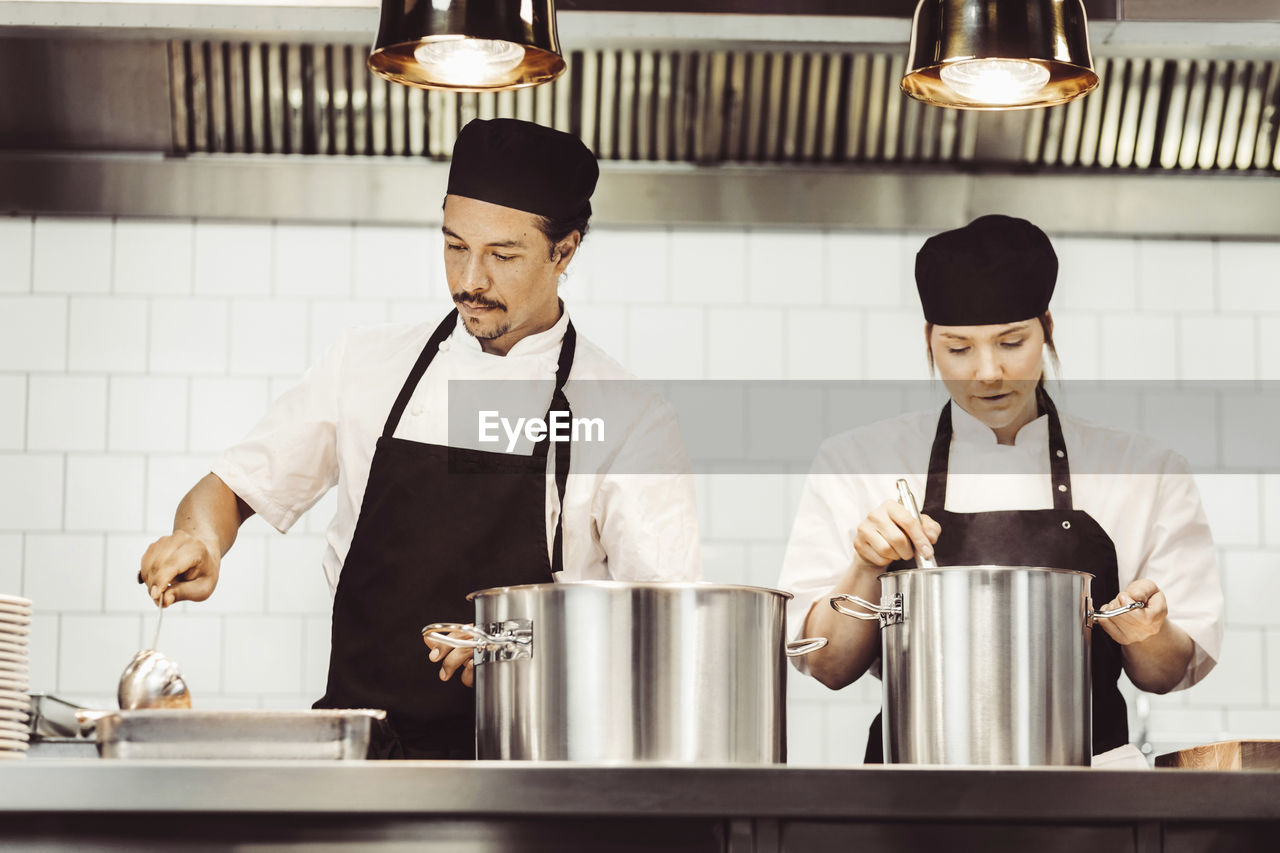 Chefs preparing food at kitchen counter