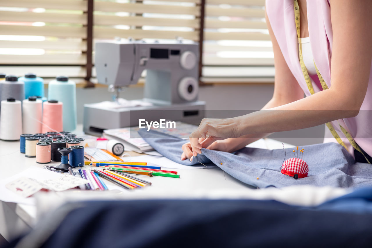 Portrait of a young, attractive woman on a stylish fashion designer's table,.