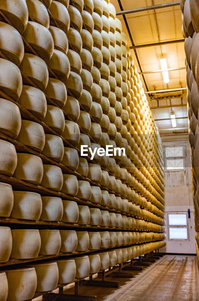 Full frame shot of patterned in building with shelves of parmesan cheese aged warehouse