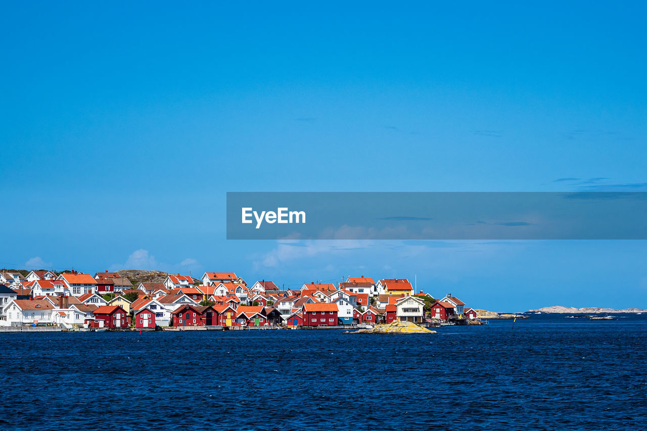 SEA BY BUILDINGS AGAINST SKY