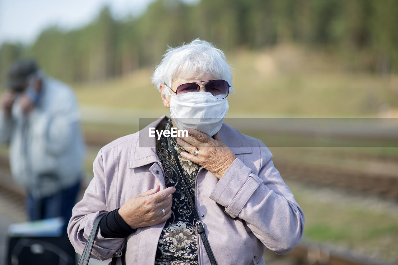 Portrait of senior woman with medical mask on face, prevention against viruses and infections