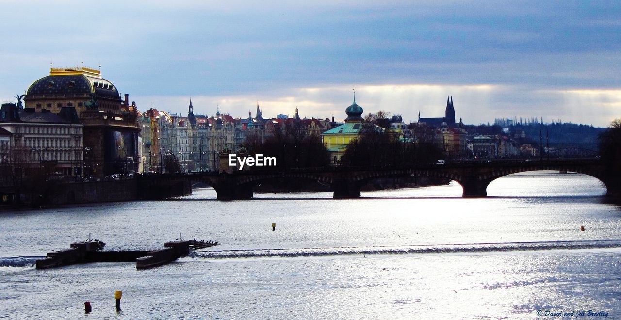 BRIDGE OVER RIVER WITH CITY IN BACKGROUND