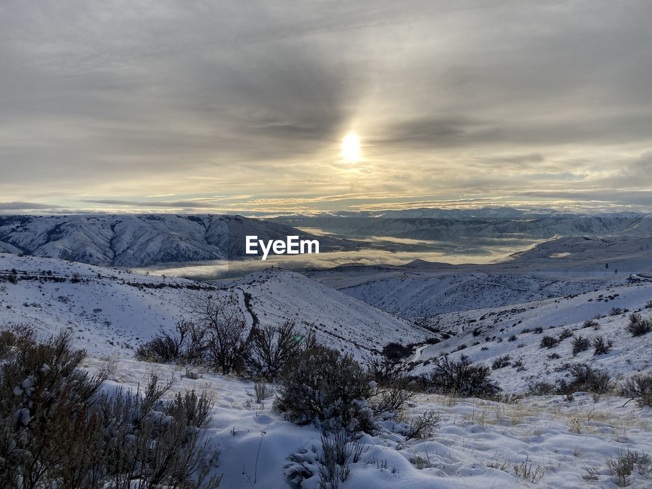 SNOW COVERED LANDSCAPE AGAINST SKY DURING SUNSET