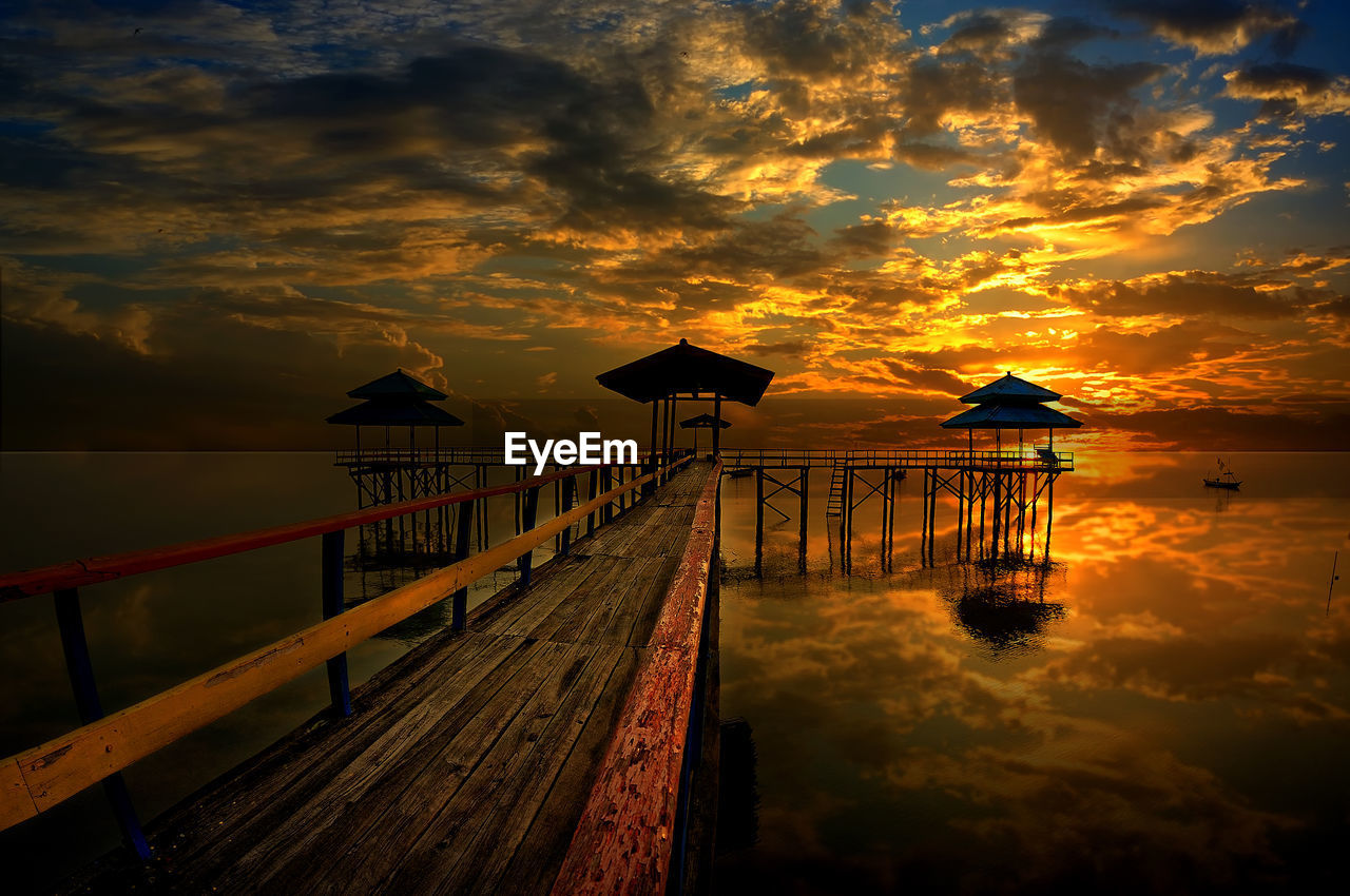 PIER OVER SEA AGAINST SKY DURING SUNSET