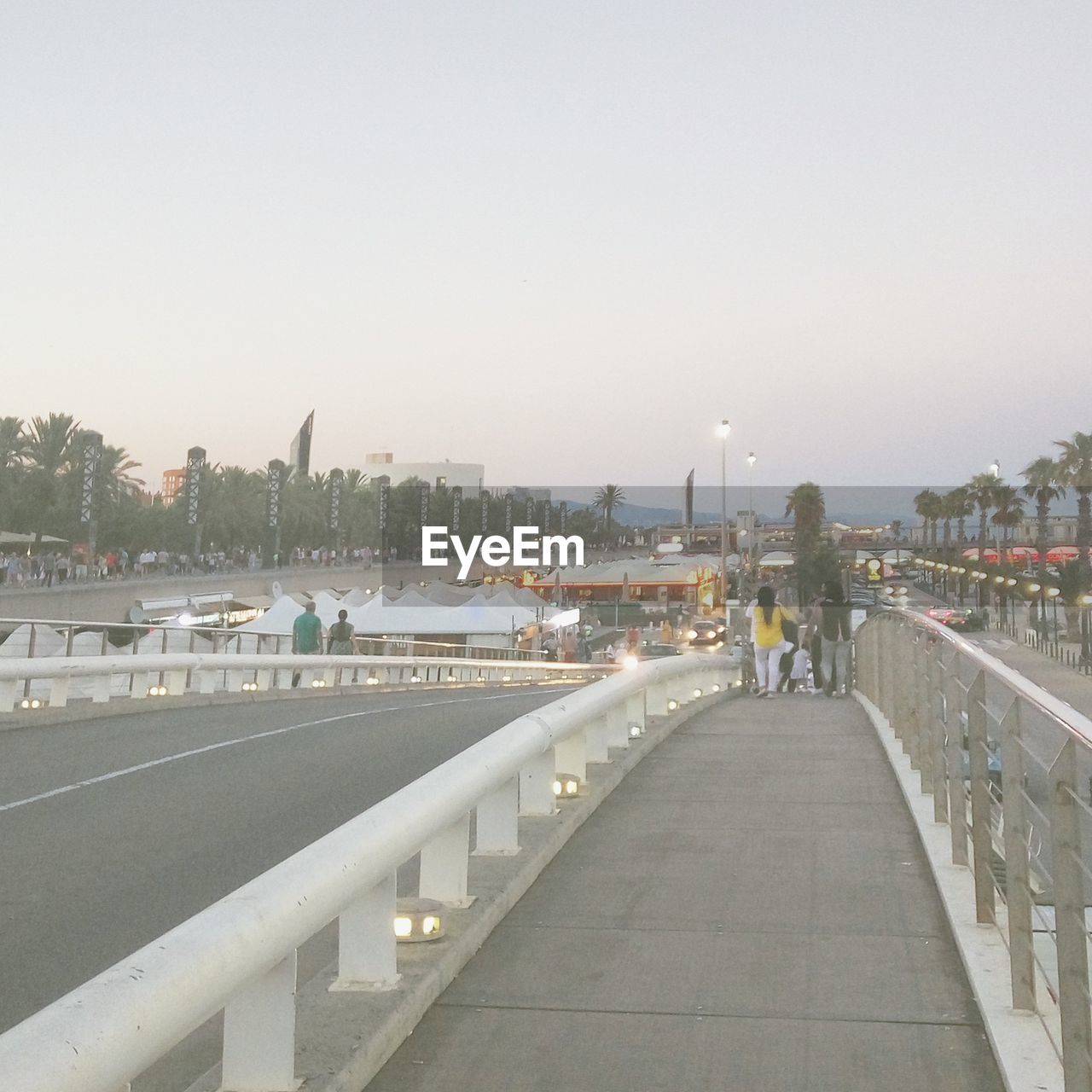 PEOPLE WALKING ON BRIDGE OVER RIVER