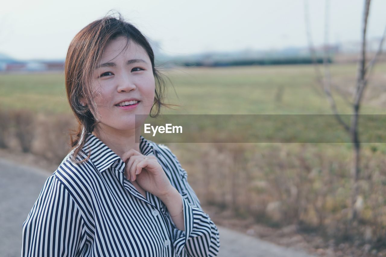 Portrait of smiling woman against sky