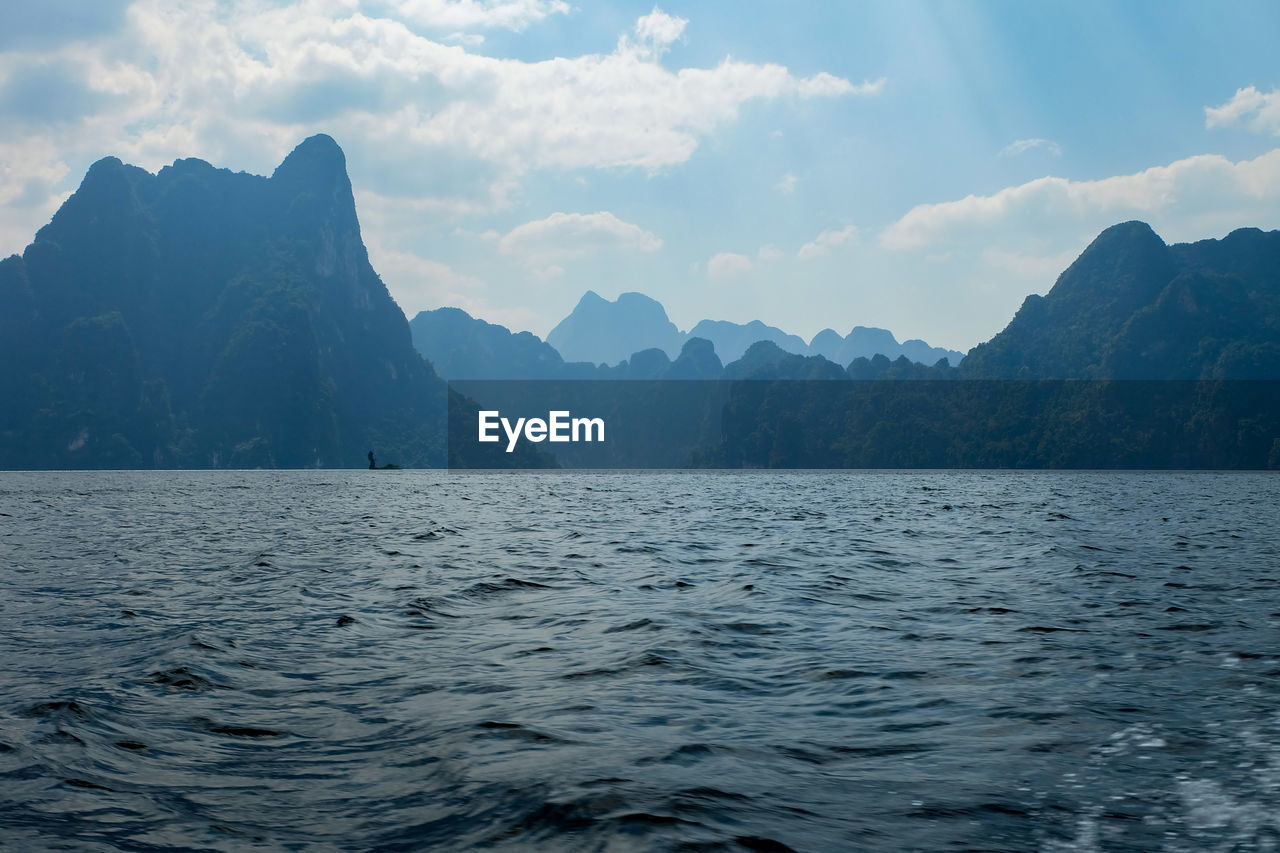 Scenic view of sea and mountains against sky