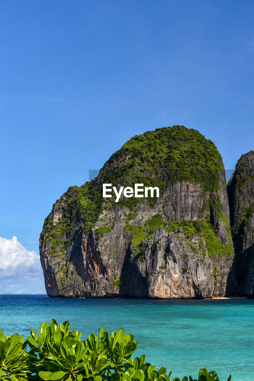 water, sea, land, beauty in nature, sky, scenics - nature, nature, rock, coast, beach, ocean, blue, travel destinations, body of water, travel, islet, tranquility, bay, shore, environment, tranquil scene, island, no people, plant, landscape, coastline, idyllic, tourism, rock formation, mountain, tropical climate, cliff, bay of water, trip, holiday, vacation, outdoors, lagoon, cove, tree, non-urban scene, terrain, day, seascape, clear sky, tropics, horizon over water, summer, cloud, sunny