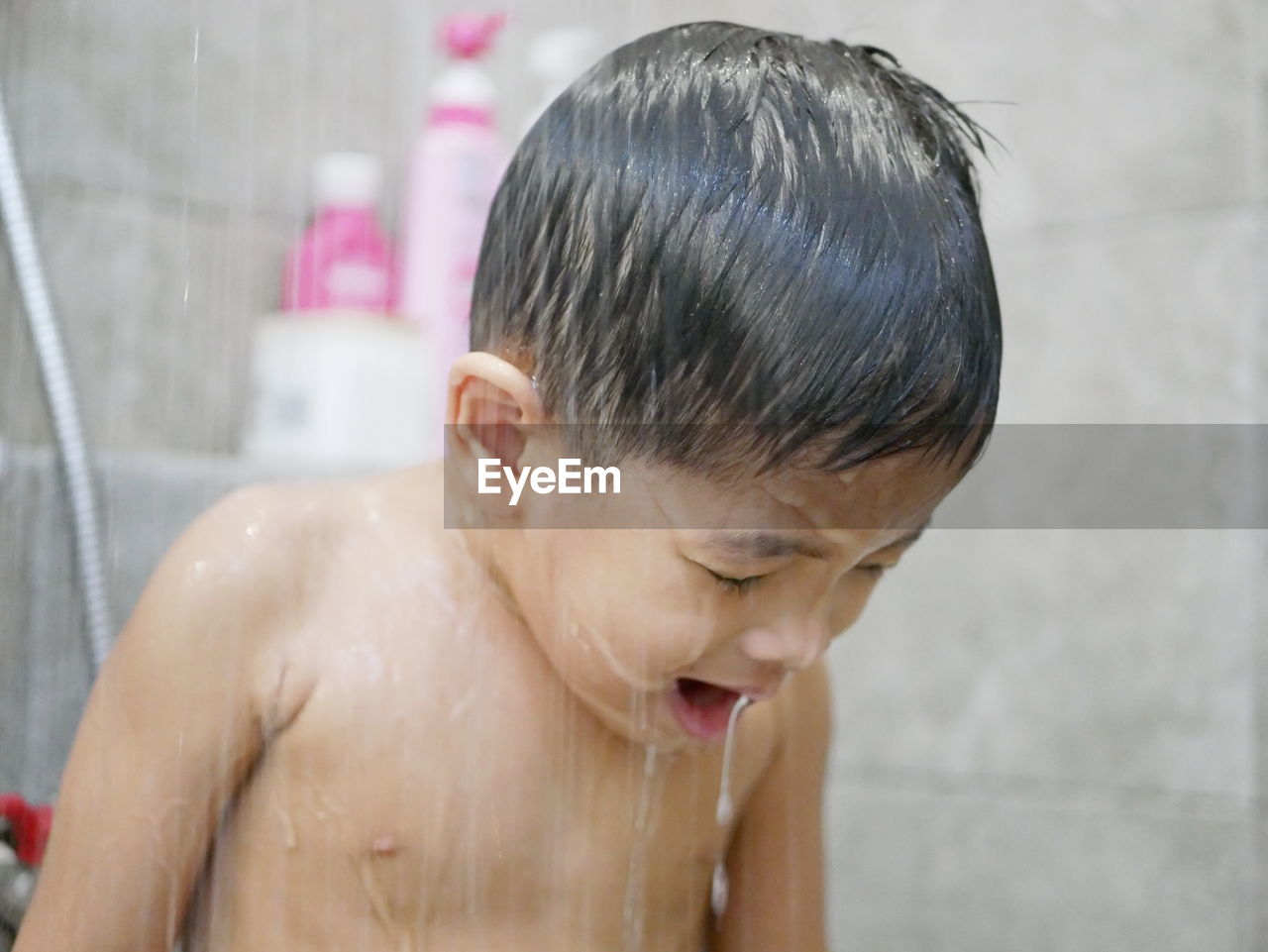 Close-up of shirtless boy taking bath in bathroom