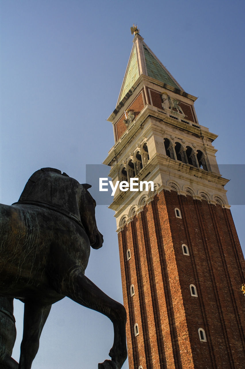 Low angle view of statue by san marco campanile
