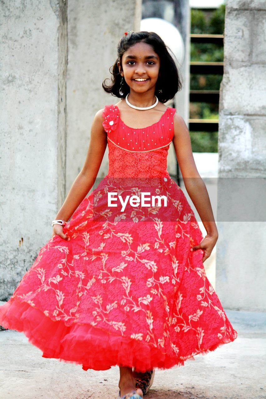 Portrait of happy girl in red dress