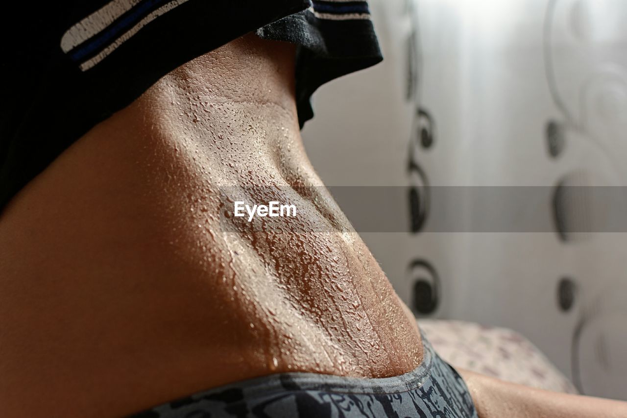 Midsection of woman with sweaty abdomen