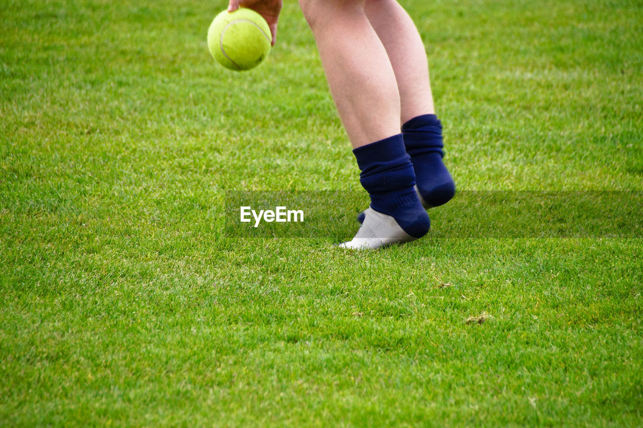 Low section of woman playing with ball on field