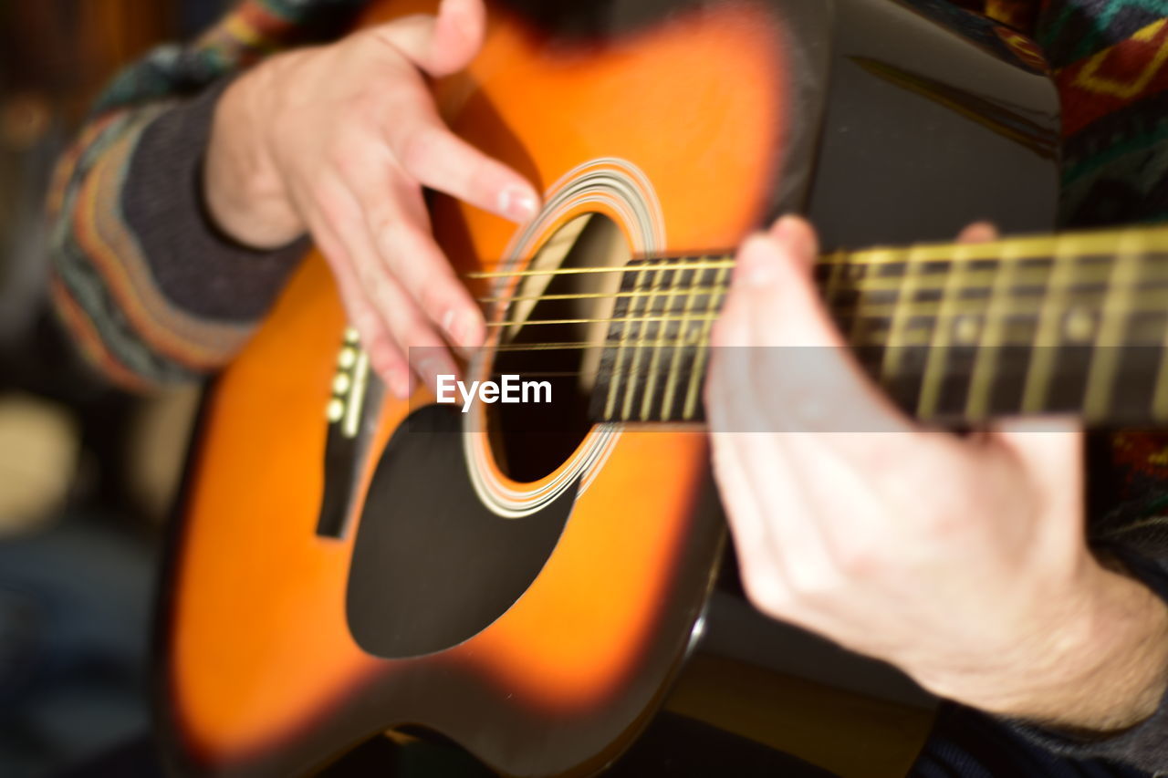 Playing acoustic guitar passionately close up photography