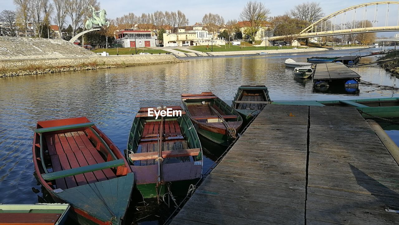 BOATS MOORED AT HARBOR AGAINST BUILDINGS