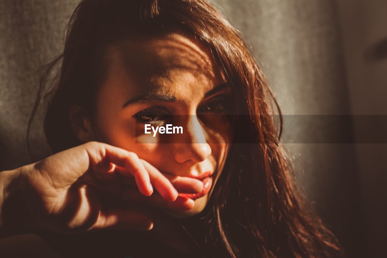 CLOSE-UP PORTRAIT OF YOUNG WOMAN WITH HANDS