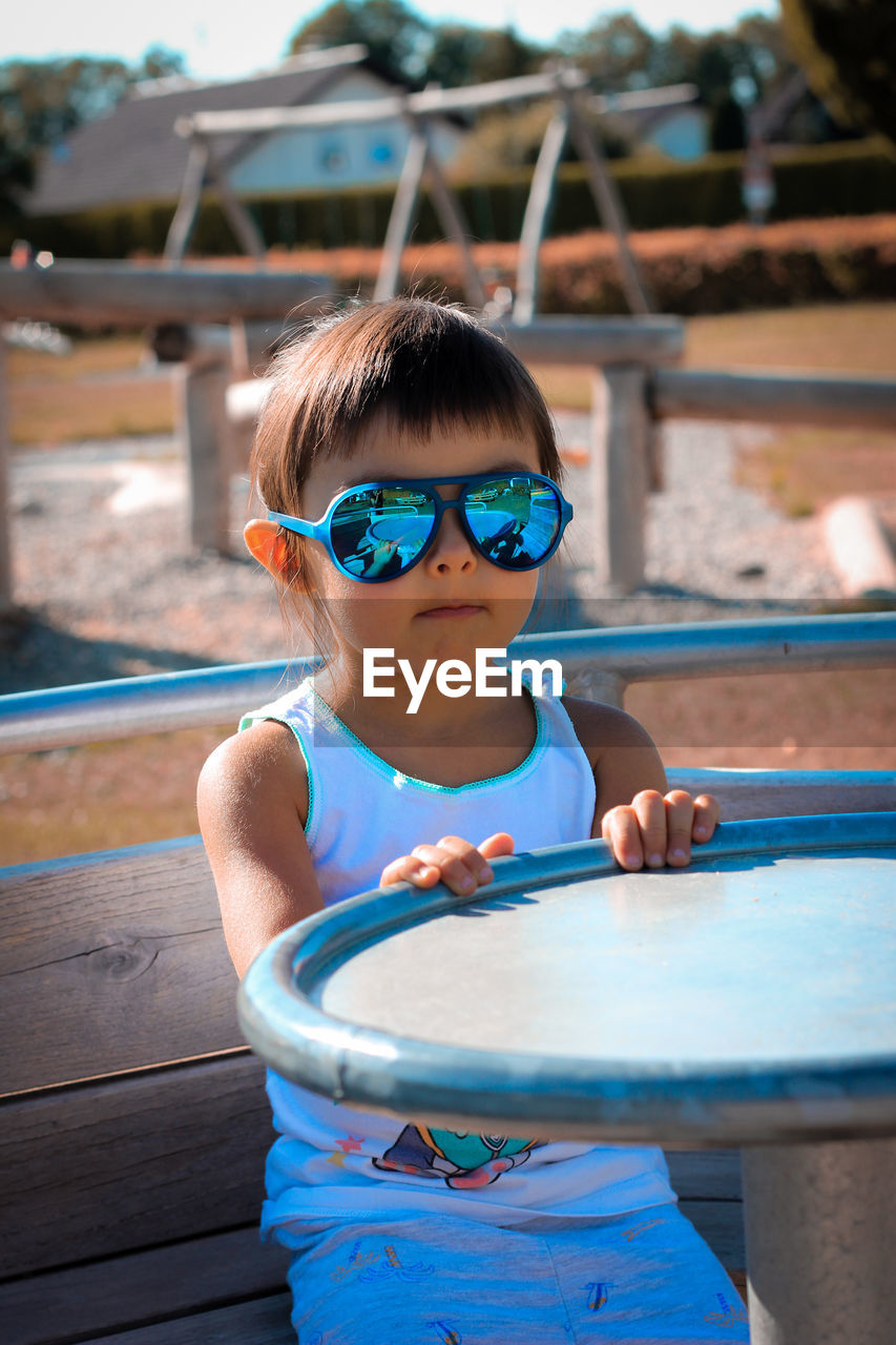 Portrait of girl in sunglasses siting outdoors