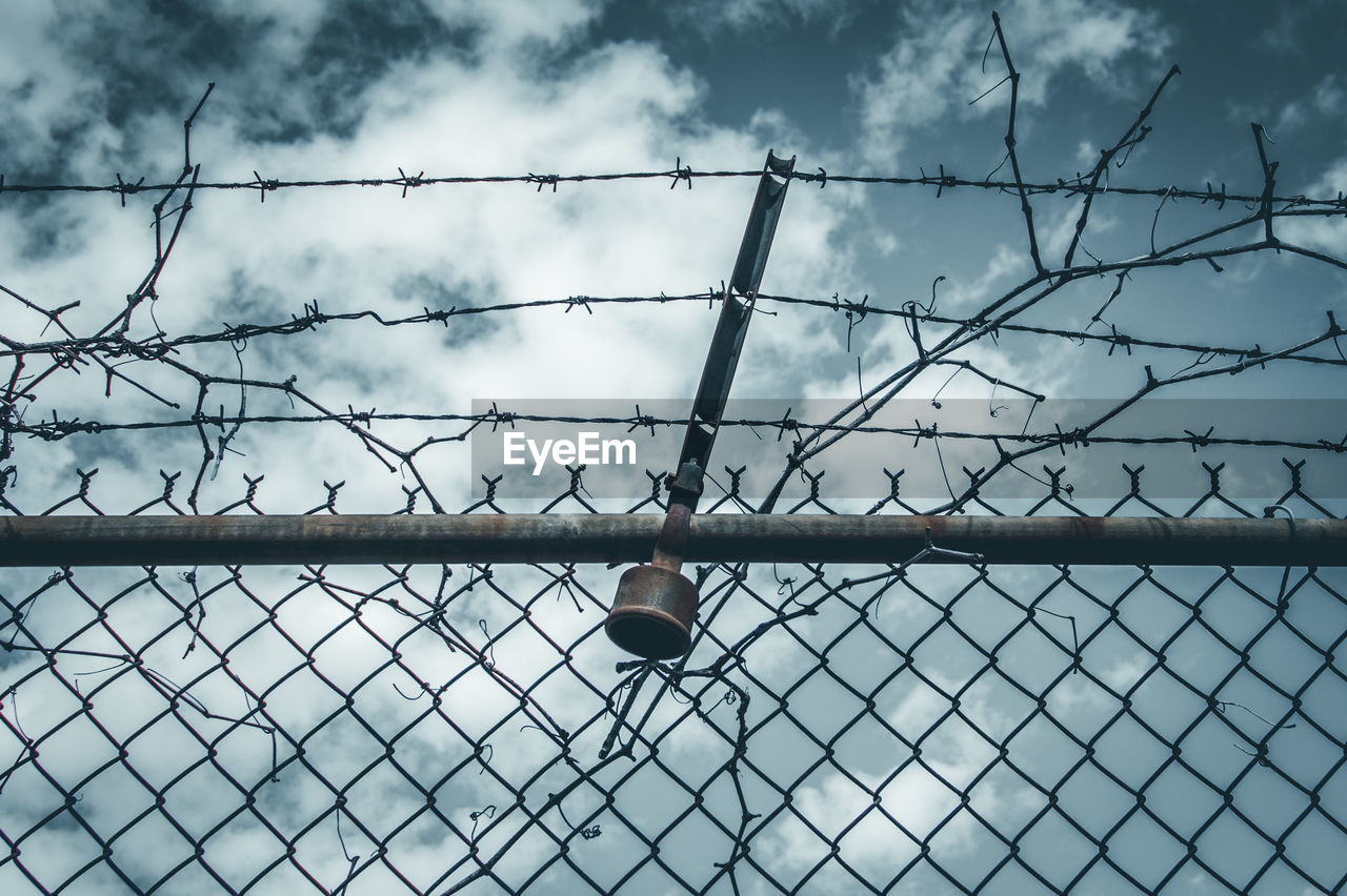 Low angle view of barbed wire against sky