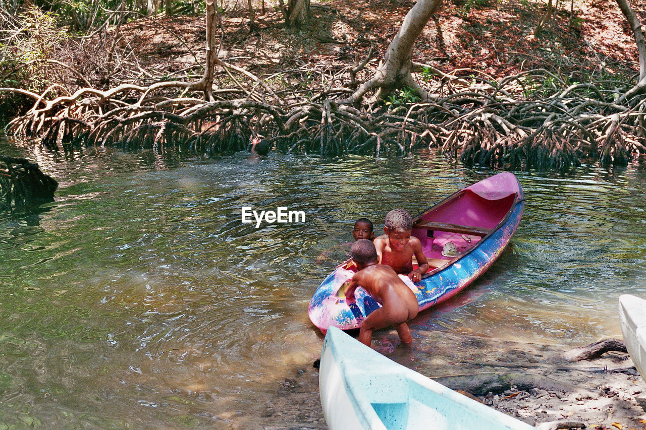 PEOPLE SWIMMING IN RIVER WITH BOAT IN BACKGROUND