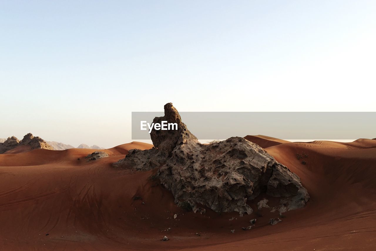 View of rock on desert against clear sky