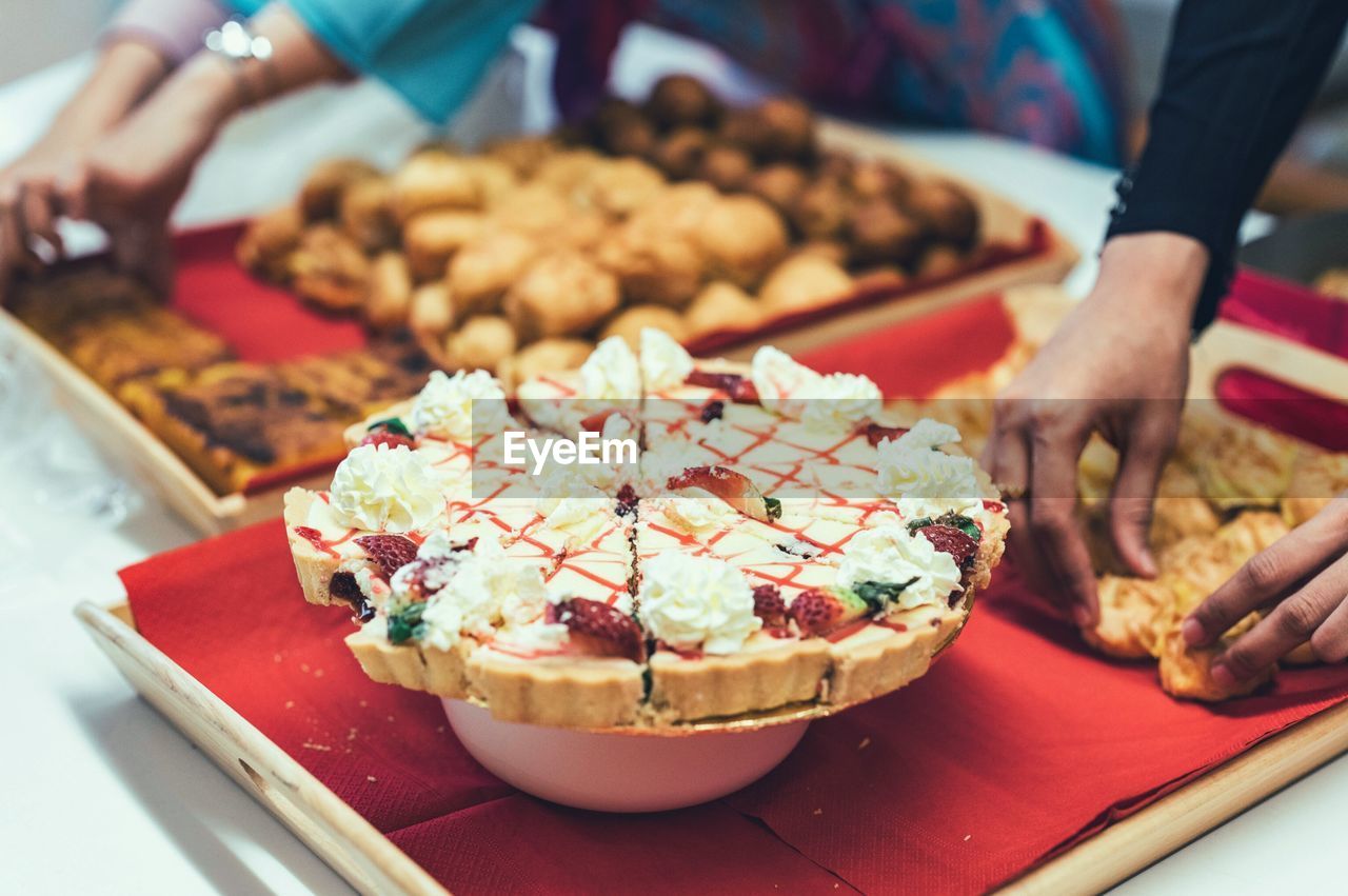 CLOSE-UP OF PERSON HOLDING FOOD IN PLATE