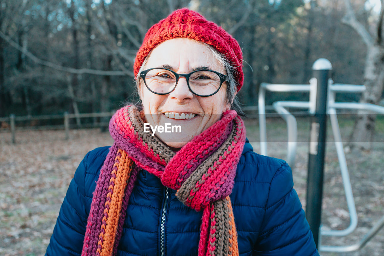 Smiling woman wearing scarf in park