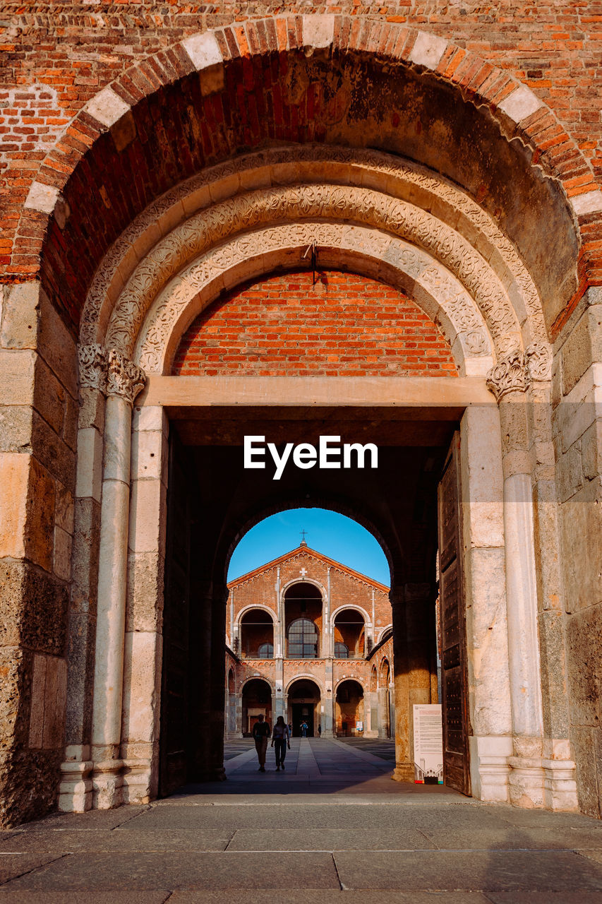 Entrance of the basilica of sant'ambrogio with people, vertical