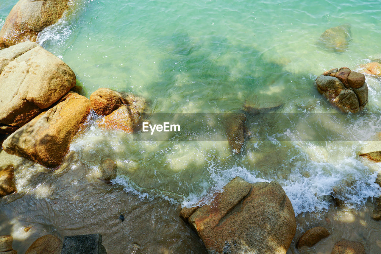 HIGH ANGLE VIEW OF ROCKS ON SHORE