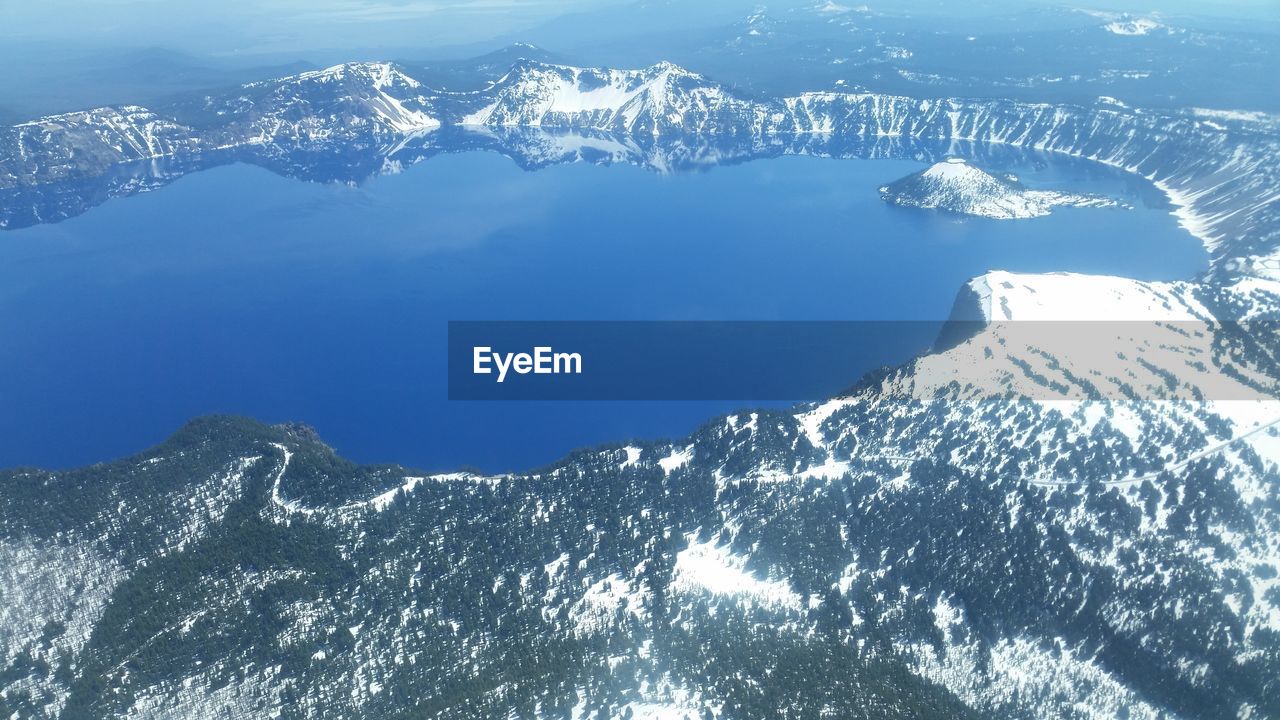 Aerial view of snowcapped mountains and sea against sky